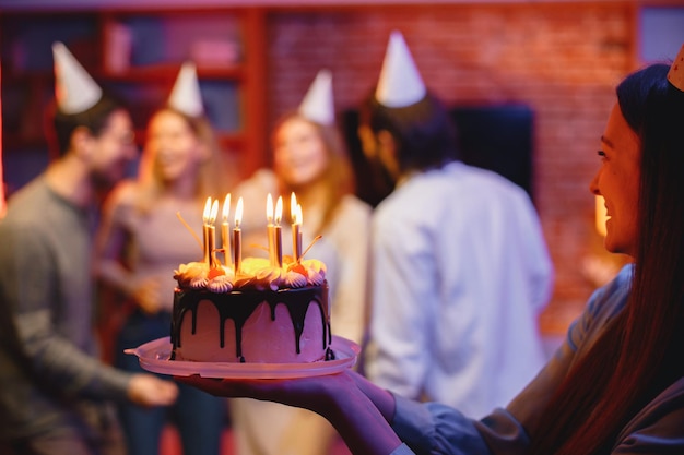 Photo photo recadrée d'une assiette avec un gâteau d'anniversaire dans les mains d'une femme