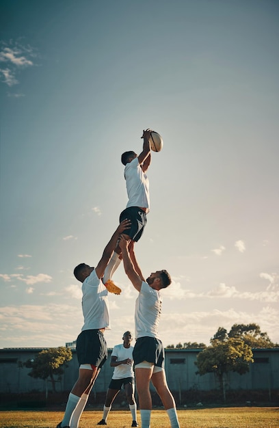 Photo photo recadrée d'un beau jeune joueur de rugby attrapant le ballon lors d'un alignement sur le terrain