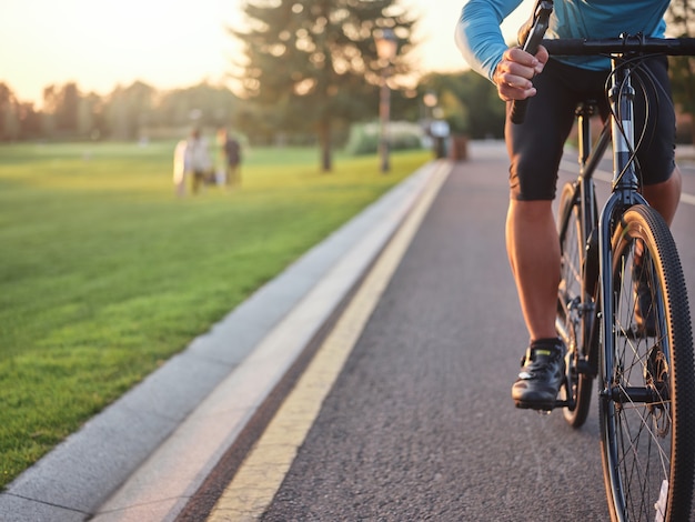 Photo recadrée d'un cycliste professionnel portant des vêtements de sport sur la route du parc