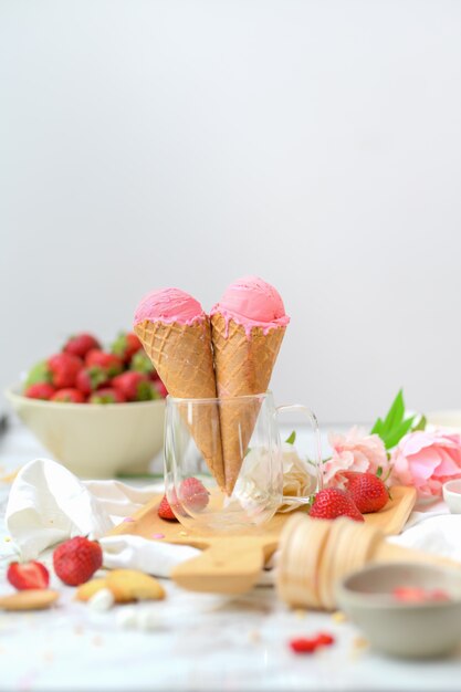 Photo recadrée de dessert d'été avec cornets de crème glacée à la fraise et garniture