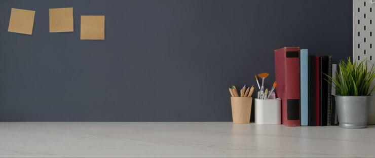 Photo photo recadrée d'un espace de travail branché avec des livres, des fournitures d'artiste, des décorations et un espace de copie sur un tableau blanc