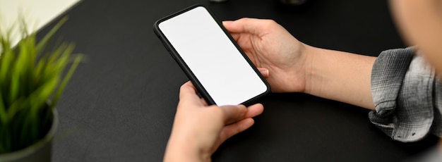 Photo recadrée d'une femme entrepreneur relaxante avec une maquette de smartphone