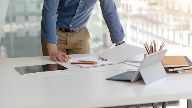 Photo recadrée d'homme d'affaires se concentrant sur son travail avec des tablettes numériques