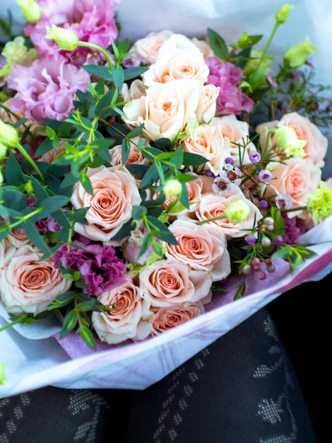 Photo recadrée de jambes de femme avec bouquet de roses mise au point sélective