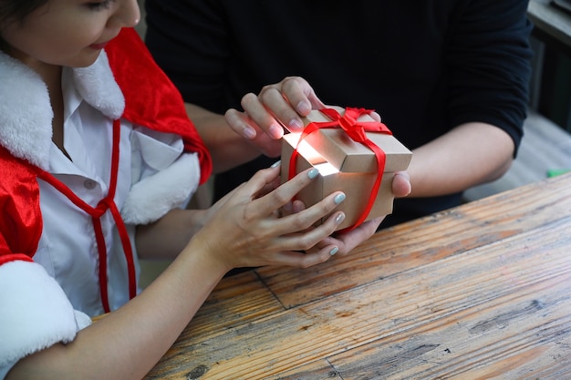 Photo recadrée jeune couple ouvrant ensemble une boîte-cadeau de Noël.