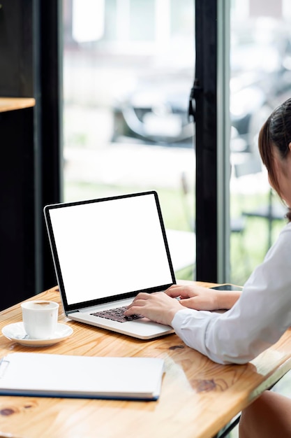 Photo recadrée d'une jeune femme travaillant sur une tablette portable, vue arrière, écran vierge de maquette pour l'affichage du produit, concept de travail en ligne. Vue verticale.