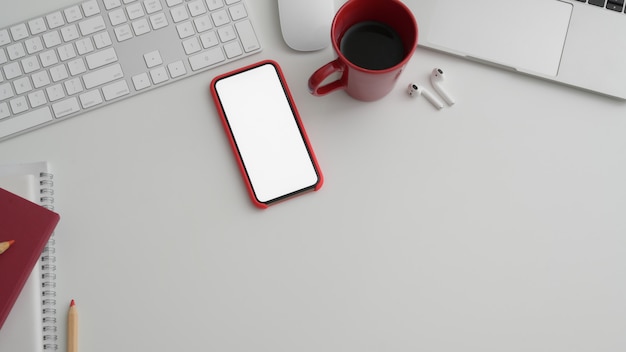 Photo recadrée de la salle de bureau avec téléphone à écran blanc et fournitures de bureau sur tableau blanc