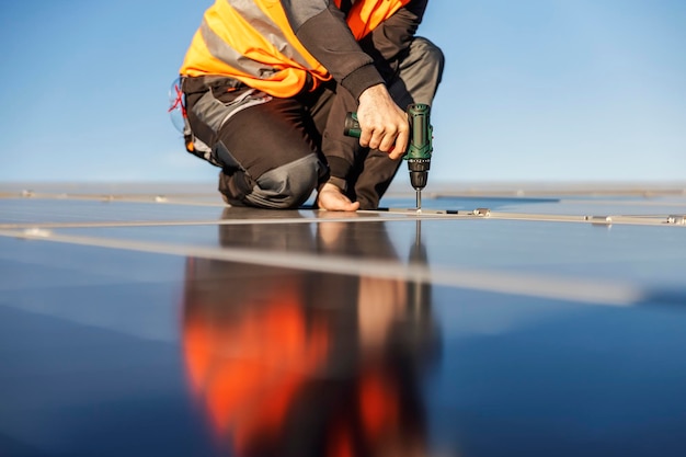 Photo recadrée d'un travailleur installant des panneaux solaires sur le toit