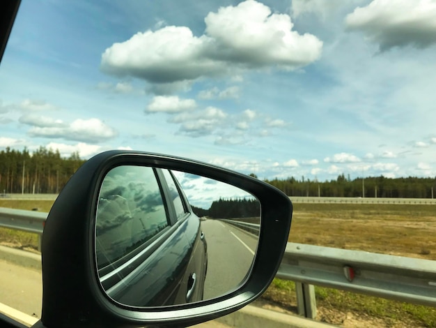 Photo de la route à travers le rétroviseur de la voiture