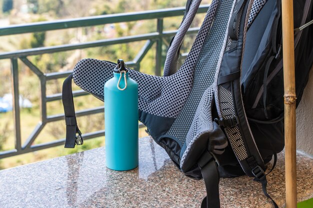 Photo d'un sac à dos de randonnée et d'une bouteille en métal pour l'eau. Voyage, randonnée, concept de randonnée. Stock photo