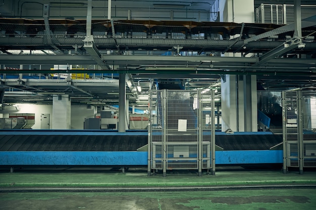 Photo sans personne d'un tapis roulant dans une zone de traitement et de tri des bagages de l'aéroport