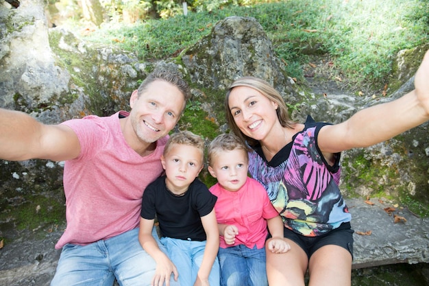 Photo selfie d'une famille heureuse de quatre personnes dans un parc d'été