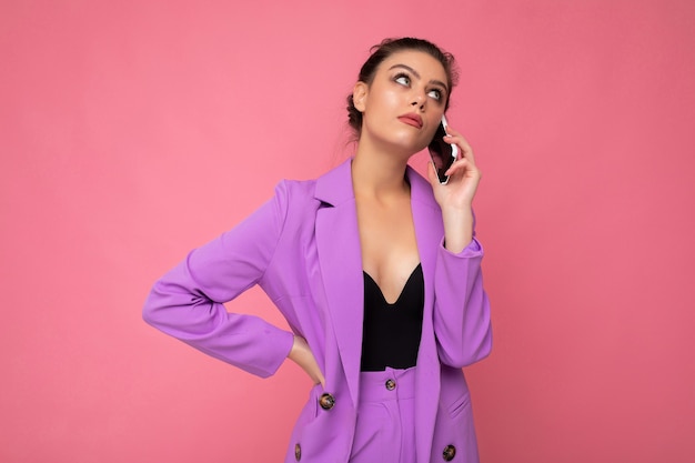 Photo de sexy belle jeune femme vêtue d'un costume violet parlant au téléphone mobile