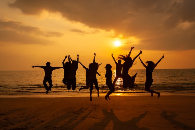 Photo de silhouette de la fête de l&#39;équipe sur la plage au coucher du soleil