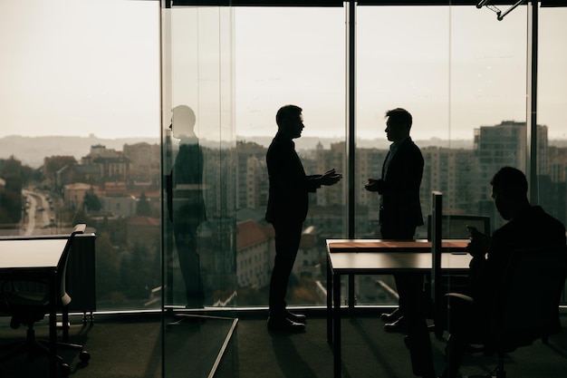 Photo de silhouette d'hommes d'affaires pendant la journée de travail dans une salle de réunion moderne