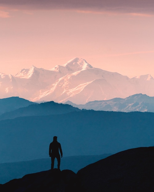 Photo photo de silhouette d'une personne en randonnée dans les montagnes et les sommets des montagnes