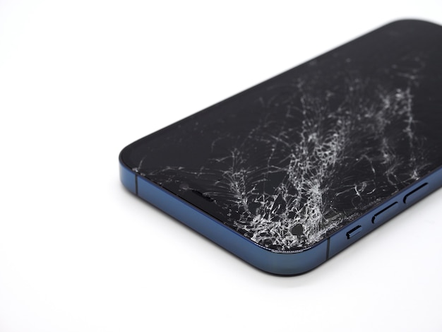 Photo photo d'un smartphone bleu avec écran endommagé cassé. smartphone moderne avec écran en verre endommagé sur une surface blanche. l'appareil doit être réparé.