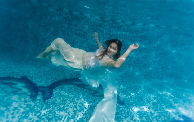 Photo Sous-marine D'une Femme En Tissu Blanc Nageant Sous L'eau