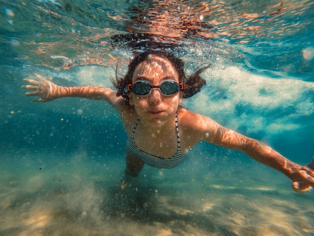 Photo sous-marine d'une fille nageant dans la mer