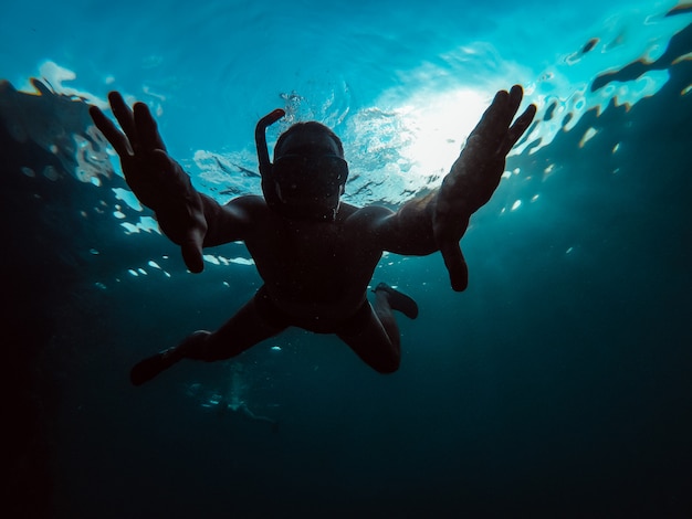 Photo sous-marine d'un homme plongeant en apnée dans une mer