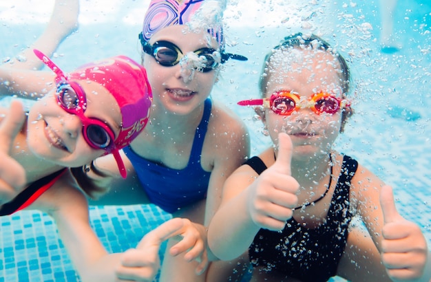 Photo sous-marine de jeunes amis dans la piscine.