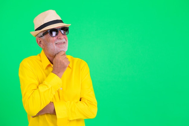 Photo de Studio de bel homme barbu touriste senior sur fond vert