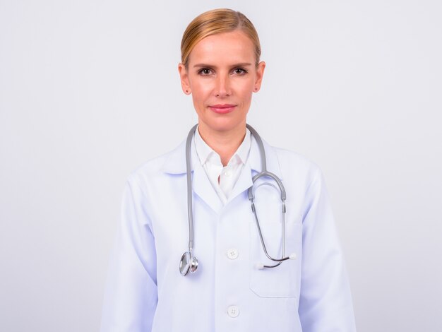 Photo de Studio de belle femme blonde médecin sur fond blanc