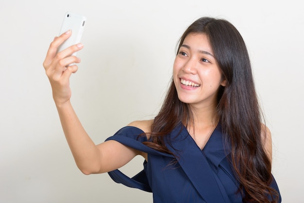 Photo de Studio de belle jeune femme d'affaires asiatique sur fond blanc