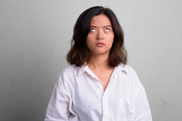 Photo de Studio de belle jeune femme aux cheveux courts contre blanc