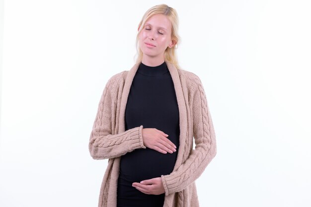 Photo de Studio de belle jeune femme enceinte aux cheveux blonds isolé sur fond blanc