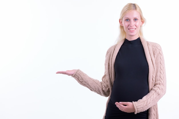 Photo de Studio de belle jeune femme enceinte aux cheveux blonds isolé sur fond blanc