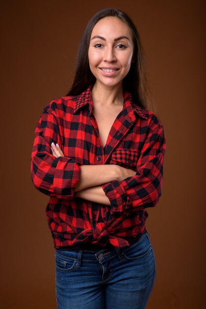 Photo de Studio de belle jeune femme sur fond marron