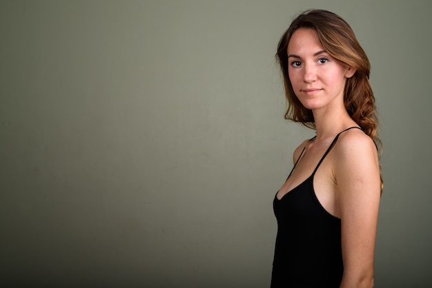 Photo de Studio de belle jeune femme portant haut sans manches sur fond coloré