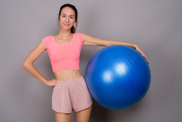 Photo de Studio de belle jeune femme prête pour la gym contre le gris