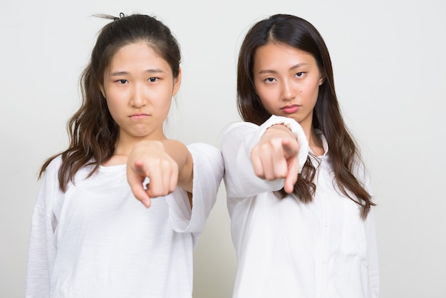 Photo de Studio de deux belles jeunes femmes coréennes comme amis ensemble sur fond blanc