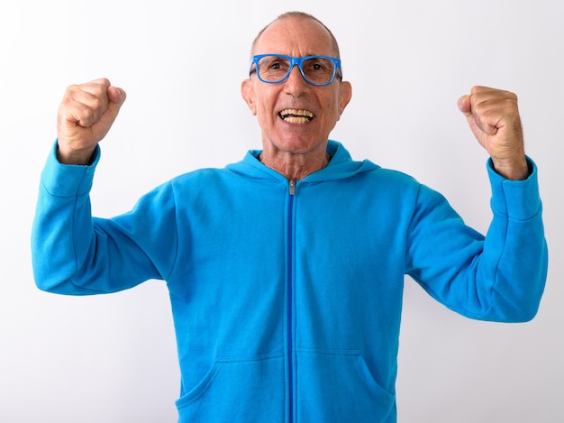 Photo de Studio d'heureux homme senior chauve souriant et à la recherche d'excité