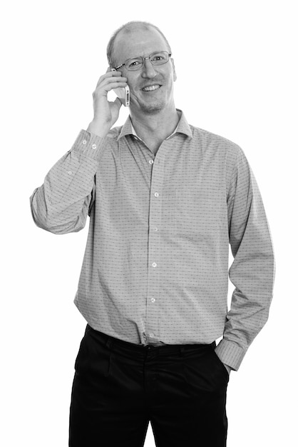 Photo de Studio d'homme d'affaires chauve avec chaume de barbe isolé sur fond blanc en noir et blanc