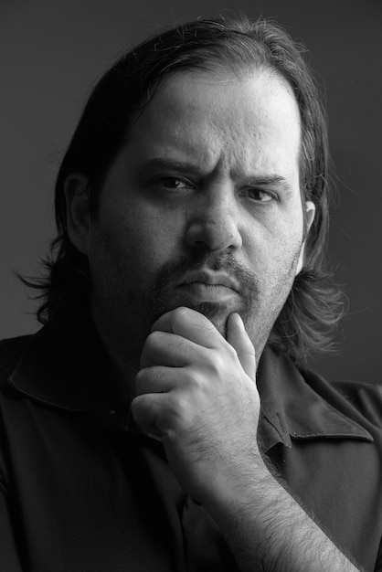 Photo de Studio d'homme barbu en surpoids isolé sur fond gris en noir et blanc