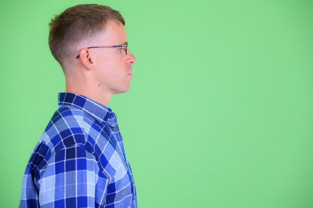 Photo de Studio d'homme hipster portant des lunettes sur fond vert