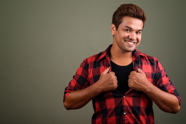 Photo de Studio d'un homme indien portant une chemise à carreaux rouge sur fond coloré