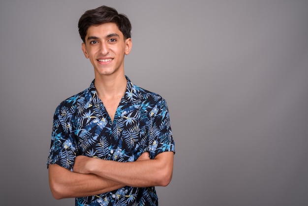 Photo de Studio de jeune adolescent persan beau portant chemise hawaïenne sur fond gris