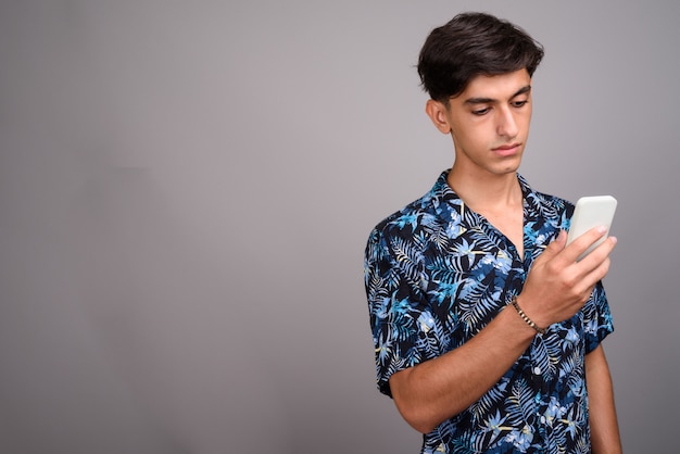 Photo de Studio de jeune adolescent persan beau portant chemise hawaïenne sur fond gris