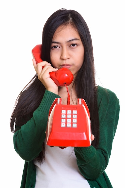 Photo de Studio de jeune adolescente asiatique parlant sur le vieux téléphone