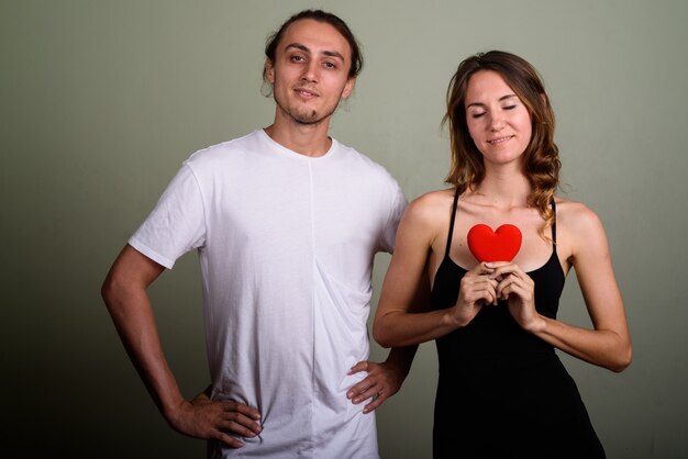 Photo de Studio de jeune bel homme et belle jeune femme ensemble sur fond coloré