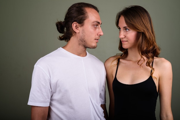 Photo de Studio de jeune bel homme et belle jeune femme ensemble sur fond coloré