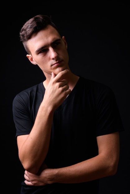 Photo de Studio de jeune bel homme sur fond noir