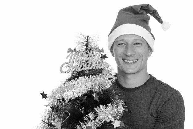 Photo de Studio de jeune bel homme prêt pour Noël isolé, noir et blanc