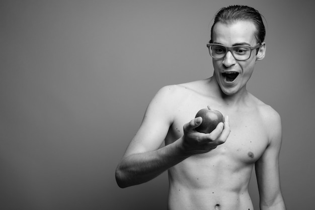 Photo de Studio de jeune bel homme torse nu contre un mur gris en noir et blanc