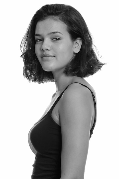 Photo de Studio de jeune belle adolescente multi-ethnique aux cheveux courts isolé sur fond blanc en noir et blanc