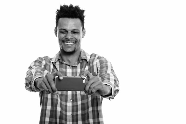 Photo de Studio de jeune homme d'affaires africain barbu aux cheveux afro isolé sur fond blanc en noir et blanc